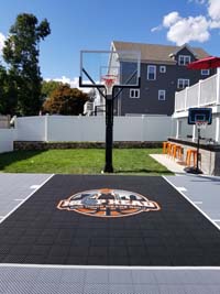 Small silver and black basketball court with Hoop Heads logo, integrated with outside entertainment area, in Boston, MA.