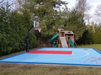 Backayard basketball court with shuffleboard, surfaced in light blue, red, and royal blue in Dartmouth, MA.