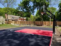 Black and red backyard basketball court in Dedham, MA.