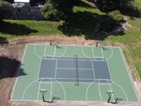 Overhead image of large combined tennis and basketball court, surfaced in olive and slate green, in Easton, MA.