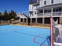 Landscape contractor now has to make the surrounding landscape look good enough to match this amazing blue hockey court with basketball in Hingham, MA.