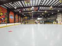 We traveled to Kapolei, Hawaii and inside to resurface two inline skate hockey rinks with Versacourt Speed Indoor tile. This is a long view of a large expanse of tiled but unlined court, with work still in progress at the far end.