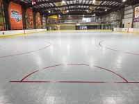 We traveled to Kapolei, Hawaii and inside to resurface two inline skate hockey rinks with Versacourt Speed Indoor tile. This is a view of the length of the completed, lined inline hocke and skating rink surface, from behind one of the goal lines.