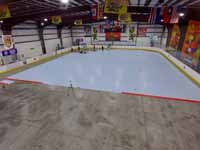We traveled to Kapolei, Hawaii and inside to resurface two inline skate hockey rinks with Versacourt Speed Indoor tile. This is a long, high view of much of the length of the first court in mid-install.