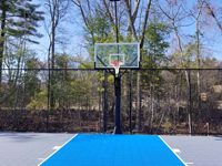 Closer view of royal blue key in grey basketball court, featuring full look at basketball hoop goal system, installed in Middleton, MA.
