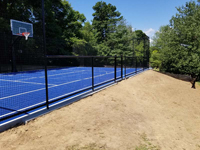 Monochrome blue hilltop home basketball court in Milton, MA. Runoff collector is visible alongside court.