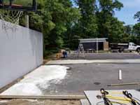Home basketball court upgrade of old asphalt court in Cape Cod village of Pocasset in Bourne, MA. Shown here in process of filling, leveling, and trimming edges to match new court size smoothly.