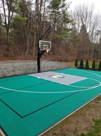Green and silver backyard basketball court with pickleball lines and Celtics logo in Upton, MA.