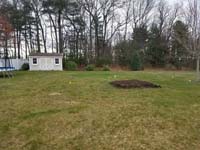 Existing lawn that will become the site of a dark green and grey backyard basketball court in Agawam, MA.