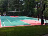 Green and red backyard basketball, volleyball and tennis court and accessories in Pembroke, MA.