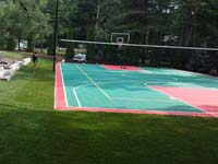 Backyard basketball surface, hoops, lights, and rebound fence in Pembroke, MA.