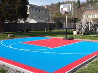 Backyard basketball court in Beverly, MA, using light blue and red outdoor tiles.