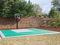 Green and silver backyard basketball court in Bridgewater, MA.