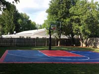 Small navy blue and red backyard basketball sport surface in Canton, MA.
