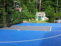 Blue and grey backyard basketball court with goal system and rebounder in West Bridgewater, MA.