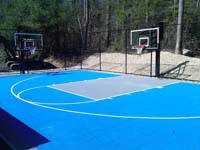 Residential basketball court in Lakeville, MA, made with light blue and ice blue tiles on concrete underlay.