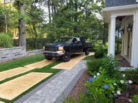 Showing steps taken to protect other parts of yard during construction of residential basketball court in shades of blue in Lexington, MA.