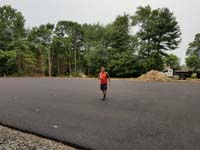 Expanse of pavement to be tiled to create a large royal blue and titanium basketball court with golf seahorse logo at Bay Club in Mattapoisett, MA.