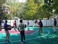 Kids enjoying almost completed church basketball court in Natick, MA.