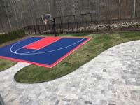 Navy blue and red home basketball court after associated landscape work was completed, located in New England, in Massachusetts, in Bristol County, in North Attleboro.