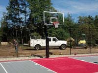 View of one end, including new hoop system, of freshly replaced town basketball court in Plympton, MA