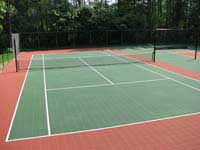 Resurfaced tennis, shuffleboard, hopscotch, multiple use court for a residential complex in Duxbury, MA, in green and rust tiles with new nets and accessories.