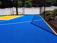 Royal blue and yellow residential basketball court in Stoneham, MA.