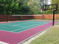 Residential combination tennis and basketball court in Sudbury, MA, in red and green Versacourt tiles.