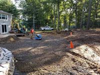 Preparing and packing ground to put in a base for graphite and orange residential basketball court replacing a dead pool in Walpole, MA.