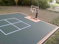 Large graphite and rust basketball court over asphalt surface in Walpole, MA.