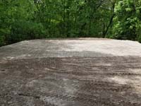 Packed sand and gravel is ready for concrete foundation of black and grey home backyard basketball court in Wellesley, MA.