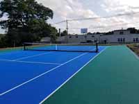 Modern resurfacing of decrepit town basketball court in Middleboro, MA for tennis and pickleball, blue and green with portable net.