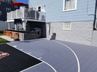 Portion of Boston Hoop Head court looking diagonally from approximately the free throw line toward house and the owner's newly installed outdoor entertaining area. Shows closer detail of surface tiles and where we worked around a protrusion at the back of the residence.