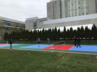 Angled view from side of pickleball court at Lawn on the D, with players enjoying the court, with the Westin Hotel in the backdrop in Boston, MA.
