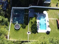 View from on high of completed home basketball court in the context of a completed backyard sanctuary in Burlington, MA.