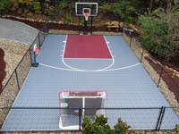 Low overhead view of silver and burgundy residential basketball court in Chelmsford, MA.