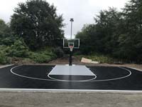 Black and silver custom basketball surface and accessories, including lighting system for night play, carved from the wilds of a yard in Easton, MA.