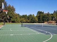 Final look down part of the length of a beautiful finished tennis and basketball court in Easton, MA.