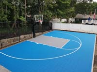 Home basketball court in light blue and titanium, with lighting system for night play, in Lexington, MA.