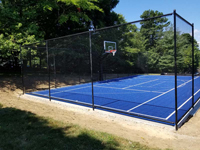 Monochrome blue hilltop home basketball court in Milton, MA.