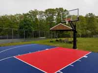Resurfaced asphalt basketball court in blue and red at Seekonk Swimming and Tennis Club in Seekonk, MA.