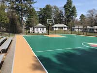 View of one end of basketball court with center custom logo and side and end hoops at Camp Wonderland in Sharon, MA.