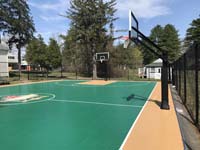 View of most of basketball court with center custom logo and side and end hoops at Camp Wonderland in Sharon, MA.