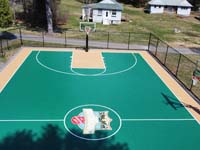 Low drone view of more than half of basketball court with center custom logo in foreground at Camp Wonderland in Sharon, MA.