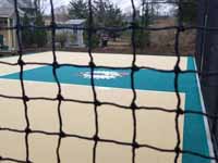 Photo from installation of a sand and emerald green residential backyard basketball court in Swampscott, MA.