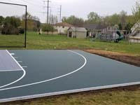 Dark green and grey backyard basketball court in Agawam, MA.