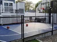 Blue and grey basketball court in Braintree, MA, after finishing landscape and hardscape touches around it were completed.