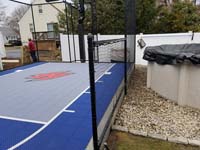 Small blue and grey backyard basketball court by pool in Braintree, MA.
