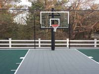 Slate green and titanium backyard basketball court in Plymouth, MA, highlighting fence and goal options.