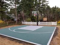 Dark green basketball court in Duxbury, MA, waiting for owner's finishing landscape touches to make it even better.